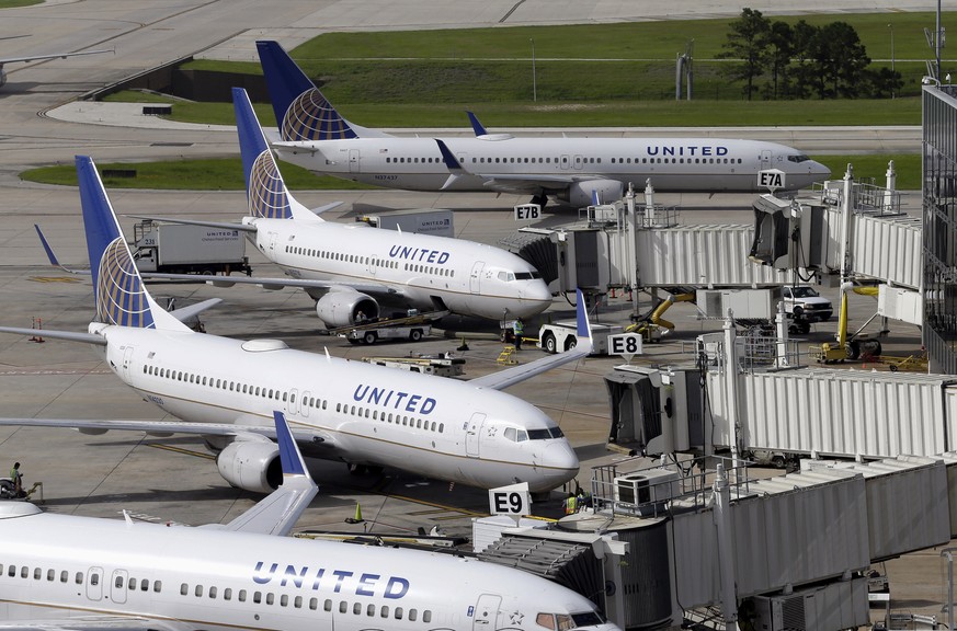 FILE - In this July 8, 2015, file photo, United Airlines planes are parked at their gates as another plane, top, taxis past them at George Bush Intercontinental Airport in Houston. United Airlines say ...