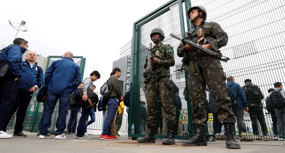 People queue at a security check to enter the main press center as Brazilian military police soldiers provide security at the 2016 Rio Olympics Park in Rio de Janeiro, Brazil, July 21, 2016. REUTERS/F ...