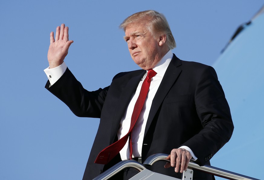 President Donald Trump waves as he steps off Air Force One as he arrives Sunday, April 9, 2017, at Andrews Air Force Base, Md. Trump was in Florida meeting with Chinese President Xi Jinping. (AP Photo ...