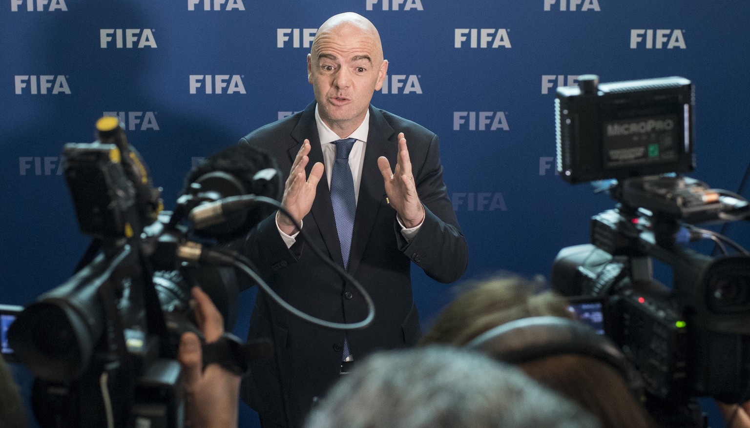 FILE - In this Oct. 14, 2016 file photo FIFA President Gianni Infantino stand between TV cameras as he attends a press conference after the FIFA Council meeting at the Home of FIFA in Zurich, Switzerl ...