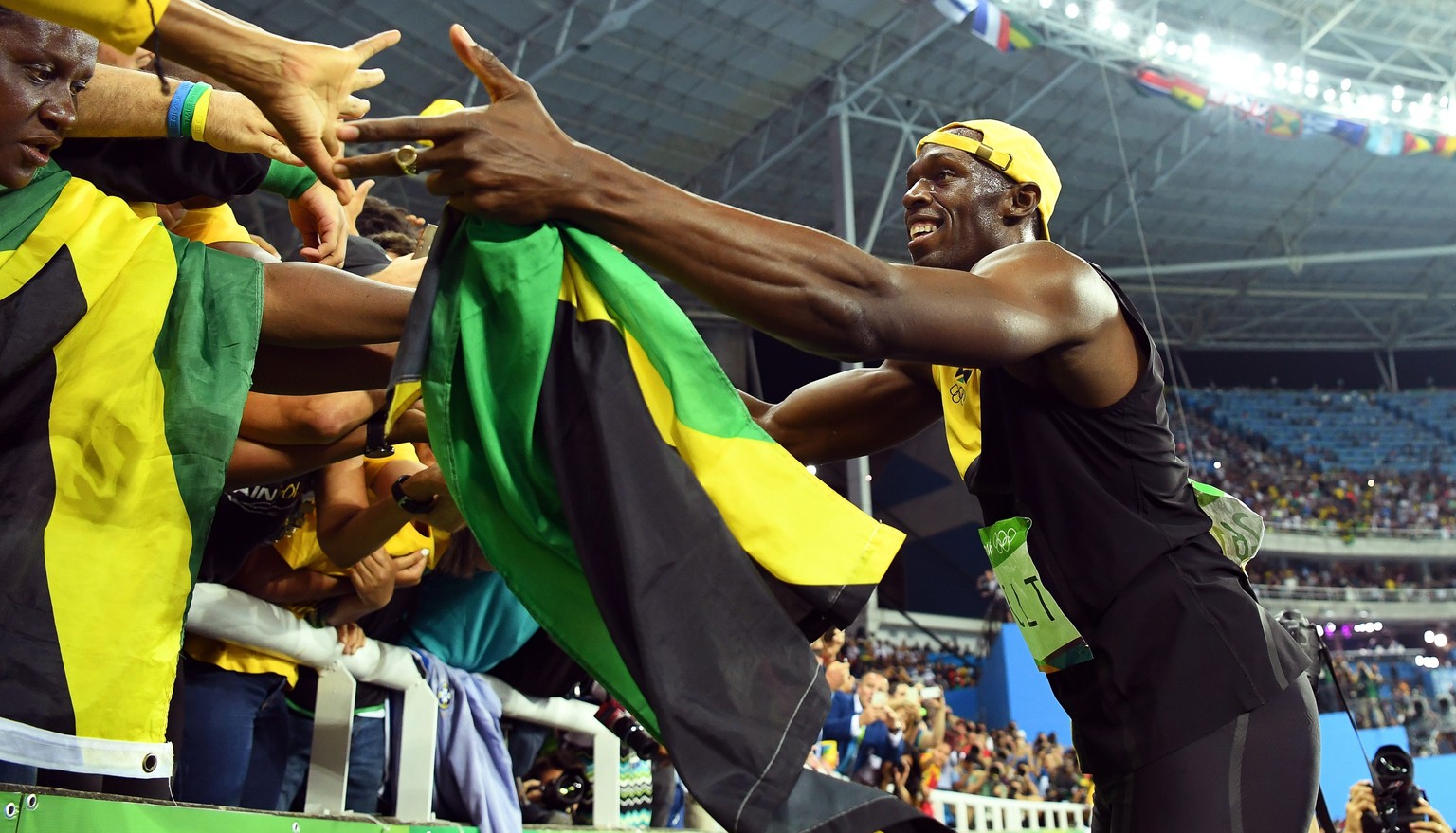 epa05486043 Usain Bolt of Jamaica celebrates with fans after winning the men&#039;s 100m final of the Rio 2016 Olympic Games Athletics, Track and Field events at the Olympic Stadium in Rio de Janeiro, ...