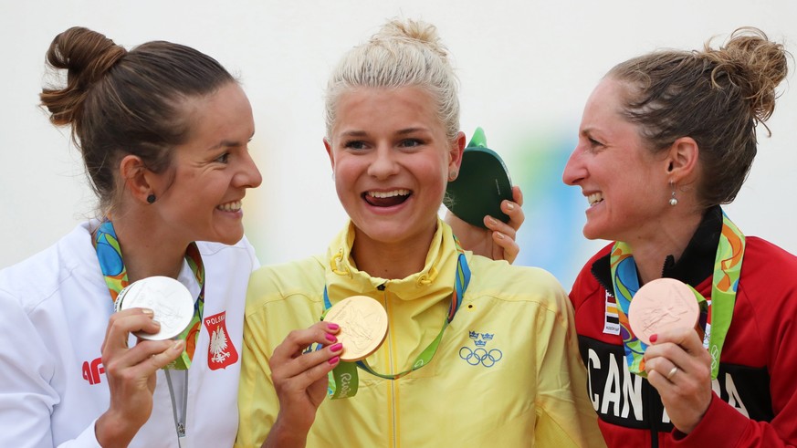 epa05502493 (L-R) Silver medalist Maja Wloszczowska of Poland, gold medalist Jenny Rissveds of Sweden, and bronze medalist Catharine Pendrel of Canada smile on the poidium during the medal ceremony fo ...