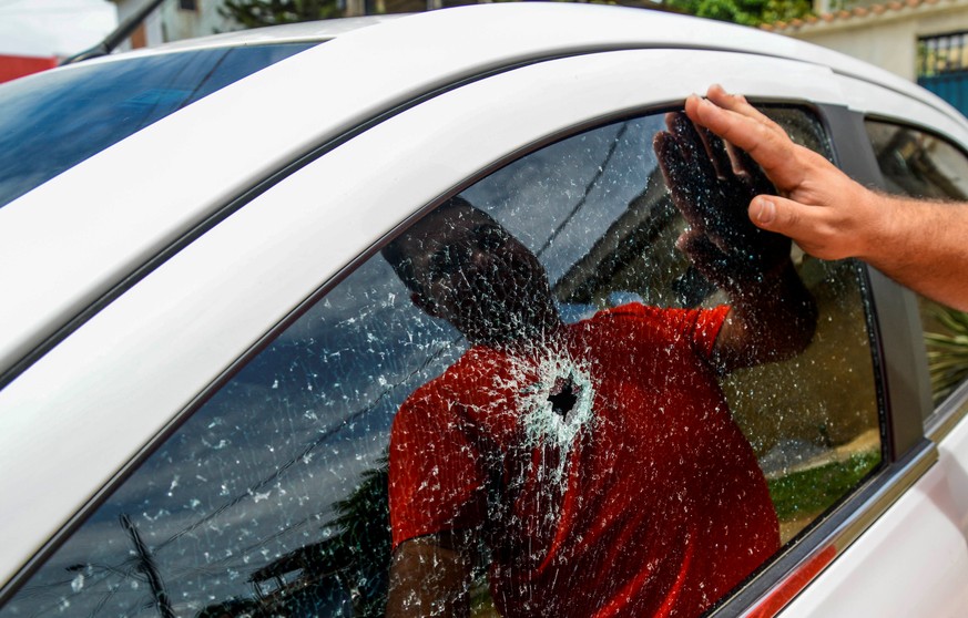 A man observes the broken window of his car, caused by a gunshot after gang attacks in Vitoria, Espirito Santo state, Brazil, February 6, 2017. REUTERS/Gabriel Lordello FOR EDITORIAL USE ONLY. NO RESA ...