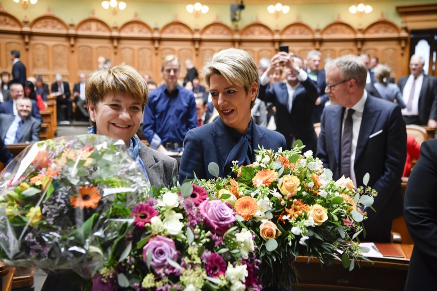 Viola Amherd, links, und Karin Keller-Sutter, freuen sich ueber ihre Wahlen zu den 118. und 119. Mitgliedern des Bundesrates waehrend der Ersatzwahl in den Bundesrat durch die Vereinigte Bundesversamm ...