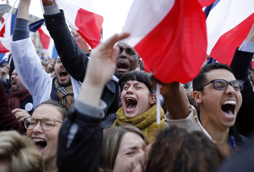 Supporters of French independent centrist presidential candidate, Emmanuel Macron react outside the Louvre museum in Paris, France, Sunday, May 7, 2017. Polling agencies have projected that centrist E ...
