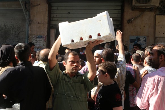 A man carries a box of vegetables he received as food aid in Aleppo, Syria August 10, 2016. REUTERS/Abdalrhman Ismail