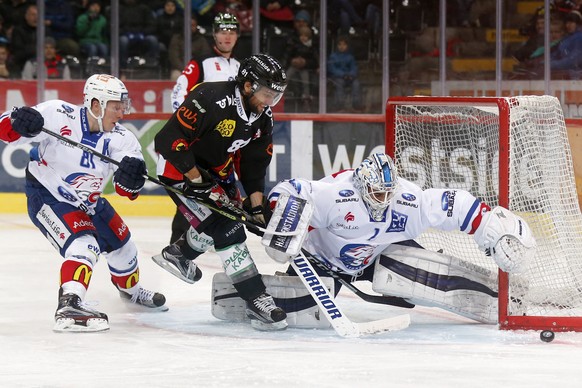 Berns Thomas Ruefenacht, Mitte, im Kampf mit Zuerichs Torhueter Niklas Schlegel und Ronalds Kenins, im Eishockey Meisterschaftsspiel der National League A zwischen dem SC Bern und den ZSC Lions, am Mo ...