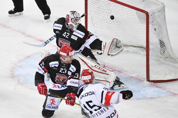 Yekaterinburg&#039;s Anatoli Golyshev, down, scores 2-2 against Rene Vydareny and goalkeeper Patrik Rybar, at the 90th Spengler Cup ice hockey tournament in Davos, Switzerland, Tuesday, December 27, 2 ...