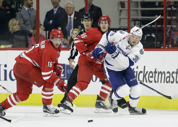 Carolina Hurricanes&#039; Elias Lindholm (16), of Sweden, and Teuvo Teravainen (86), of Finland, skate with Tampa Bay Lightning&#039;s Tanner Richard (38) during the third period of an exhibition NHL  ...