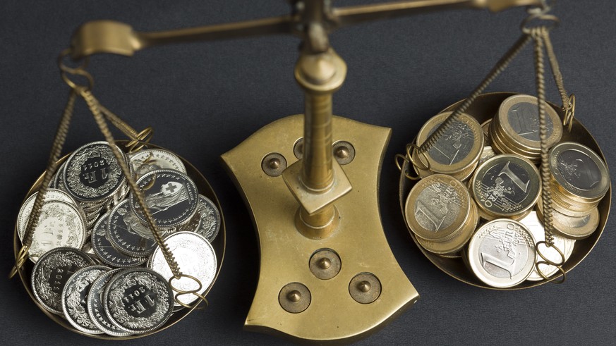 ARCHIVBILD - EURO-FRANKEN-KURS RAST AUF 1,14 MARKE ZU - A pair of balances filled with coins of 1 Swiss Franc (left) and coins of 1 Euro (right), pictured on July 20, 2011. (KEYSTONE/Martin Ruetschi)