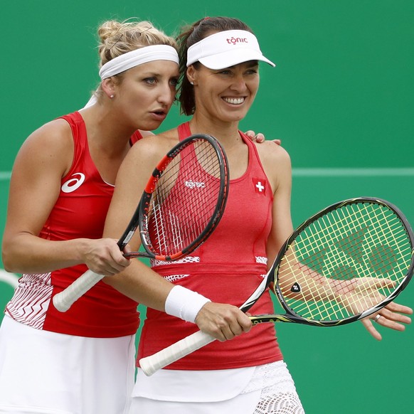 epa05465112 Timea Bacsinszky (L) and Martina Hingis of Switzerland talk during the women’s second round doubles match against Bethanie Mattek-Sands and Coco Vandeweghe of USA of the Rio 2016 Olympic G ...