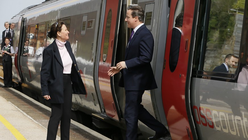 Britain&#039;s Prime Minister David Cameron is met by Conservative candidate Anne Marie Morris as he steps off a train in Dawlish, in Devon, England, Friday, April 10, 2015. Britain goes to the polls  ...