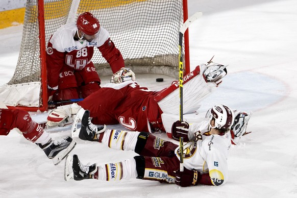 Geneve-Servette&#039;s defender Romain Loeffel, right, scores the 0:1 against Lausanne&#039;s goaltender Cristobal Huet, center, of France, past Lausanne&#039;s defender Matteo Nodari, left, during a  ...