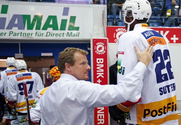 EHC Biel Cheftrainer Kevin Schlaepfer, Mitte, gratuliert seinem Spieler Dave Sutter zum Sieg auf dem Weg in die Garderobe nach dem Eishockey-Meisterschaftsspiel der National League A zwischen den Klot ...