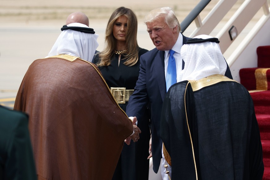 U.S. President Donald Trump, top right, accompanied by first lady Melania Trump, center, shakes hands with Saudi King Salman during a welcome ceremony at the Royal Terminal of King Khalid Internationa ...
