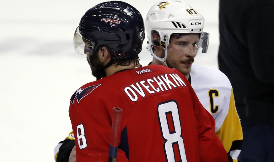 Pittsburgh Penguins coach Mike Sullivan, left, waits to greet Washington Capitals left wing Alex Ovechkin (8), from Russia, who is talking with Penguins center Sidney Crosby (87) after Game 7 in an NH ...