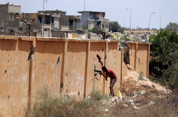 A member of the Libyan forces allied with the U.N.-backed government looks at Islamic State fighters&#039; positions in Sirte, Libya, July 15, 2016. REUTERS/Goran Tomasevic