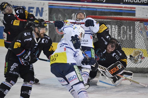 Die Fribourger Tristan Vauclair, Marc Abplanalp und Torhueter Benjamin Conz, von links, und der Tessiner Christian Stucki, Mitte, kaempfen um den Puck im Eishockey-Platzierungsspiel der National Leagu ...