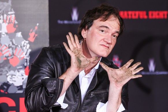 Quentin Tarantino poses with dirty hands at a hand and footprint ceremony at the TCL Chinese Theatre on Tuesday, Jan. 5, 2016, in Los Angeles. (Photo by Rich Fury/Invision/AP)