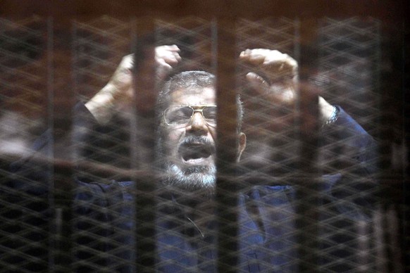 epa04802442 Ousted Egyptian President, Mohamed Morsi reacts inside defendants cage in the courtroom as the judge is reading a verdict against him in Cairo, Egypt, 16 June 2015. A Cairo court on 16 Jun ...
