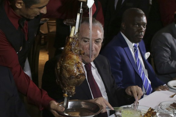 Brazil&#039;s President Michel Temer, center, alongside Angola&#039;s Ambassador to Brazil, Nelson Manuel Cosme, attend a steak dinner at a traditional Brazilian barbecue restaurant after a meeting on ...