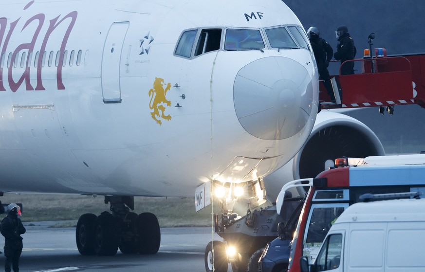 Police stand around the aircraft after passengers were evacuated from a hijacked Ethiopian Airlines Plane on the airport in Geneva, Switzerland, Monday, Feb. 17, 2014. A hijacked aircraft traveling fr ...