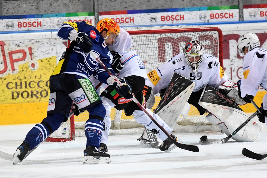 Ambris Janne Pesonen, Fribourgs Goalie Dennis Saukkonen und Fribourgs Sebastian Schilt, von links, im Spiel um den Puck waehrend dem Eishockey-Spiel in der Platzierungsrunde 6 der National League A zw ...