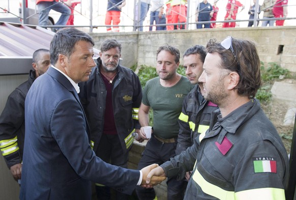 epa05508922 A handout image provided by the Chigi Palace shows Italian premier Matteo Renzi meeting some rescuers in Amatrice, central Italy, 24t August 2016. The quake was felt across a broad section ...