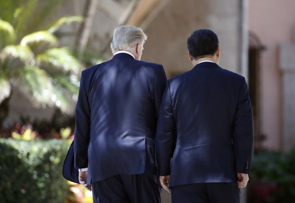 President Donald Trump and Chinese President Xi Jinping walk together at Mar-a-Lago, Friday, April 7, 2017, in Palm Beach, Fla. Trump was meeting again with his Chinese counterpart Friday, with U.S. m ...