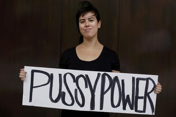 Jessica Wilson poses for a portrait with her sign as she takes part in a protest against Republican presidential candidate Donald Trump outside the Trump International Hotel and Tower in Chicago, Illi ...