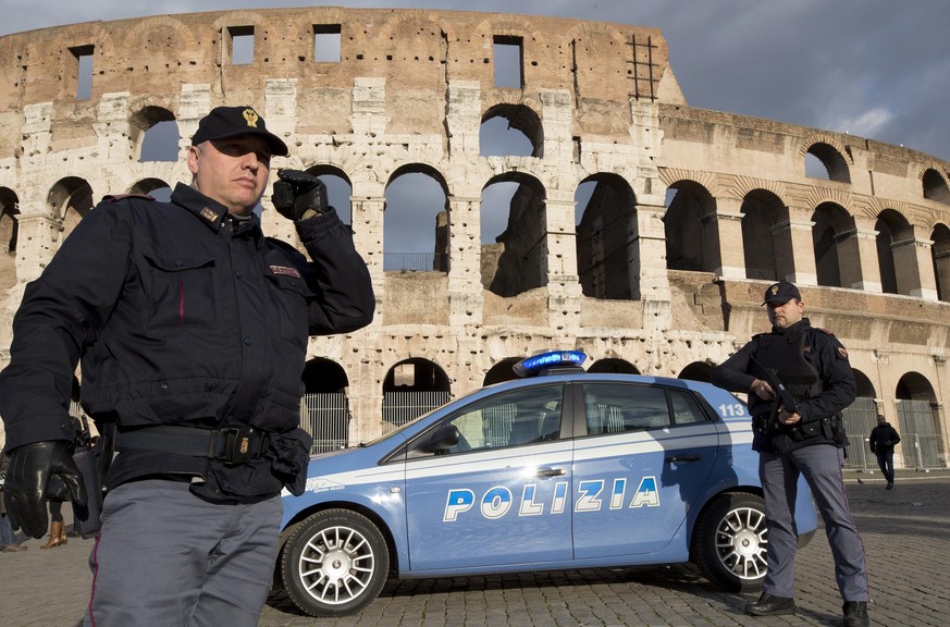 epa04552485 Italian policemen stand guard at the Colosseum in Rome, Italy, 09 January 2015. Police are stepping up security measures at all the institutional and diplomatic targets following an attack ...