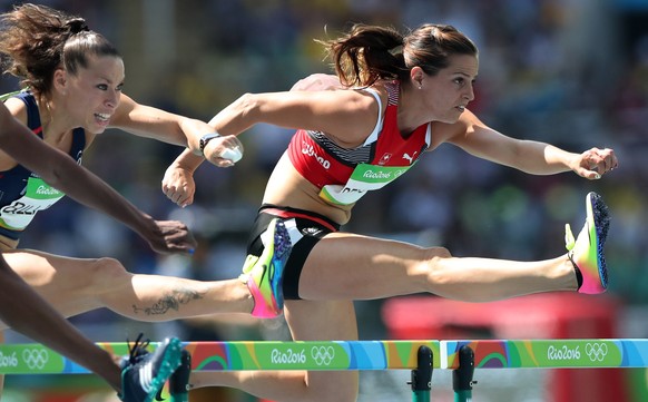 Switzerland&#039;s Clelia Reuse-Rard, right, and France&#039;s Cindy Billaud compete in a women&#039;s 100-meter hurdles heat during the athletics competitions of the 2016 Summer Olympics at the Olymp ...