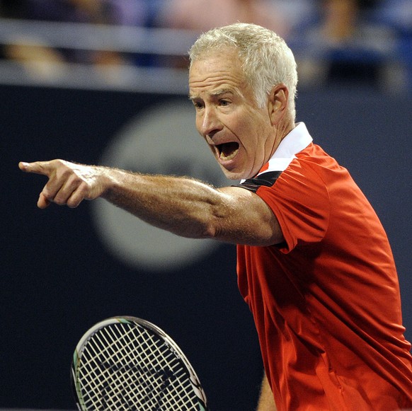 FILE - In this Aug. 28, 2015, file photo, John McEnroe reacts during a game against Jim Courier in the Connecticut Open Men&#039;s Legends event in New Haven, Conn. McEnroe says he is returning to Gra ...