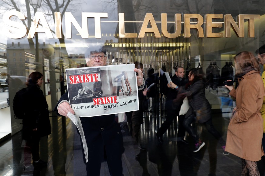 Activists hold placards which read &quot;Sexist&quot; during a demonstration in front of a Yves Saint Laurent shop in Paris, France, March 7, 2017. France&#039;s advertising watchdog on Monday said it ...
