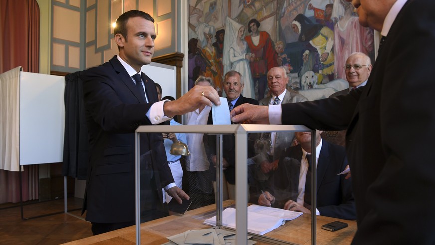 epa06034737 French President Emmanuel Macron (L) casting his vote in the second round of the French legislative elections at the City Hall in Le Touquet, France, 18 June 2017. France holds the second  ...