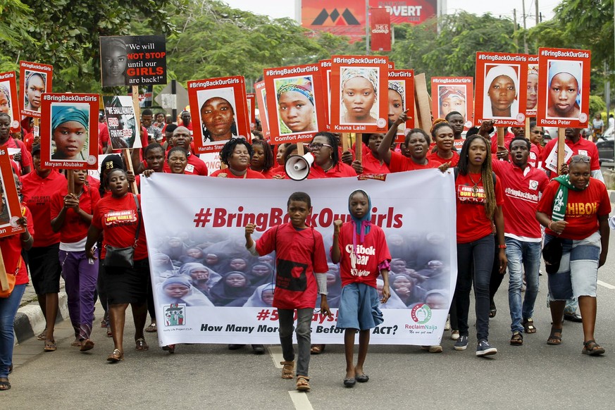 Bring Back Our Girls (BBOG) campaigners hold banners as they walk during a protest procession marking the 500th day since the abduction of girls in Chibok, along a road in Lagos August 27, 2015. The I ...