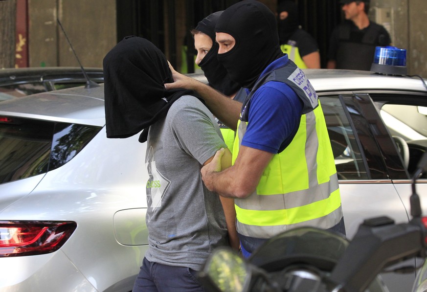 epa06040471 Spanish National policemen escort a suspected Moroccan jihadist (L) after his arrest in Madrid, Spain, 21 June 2017. Spanish police authorities have arrested three Moroccan men, including  ...