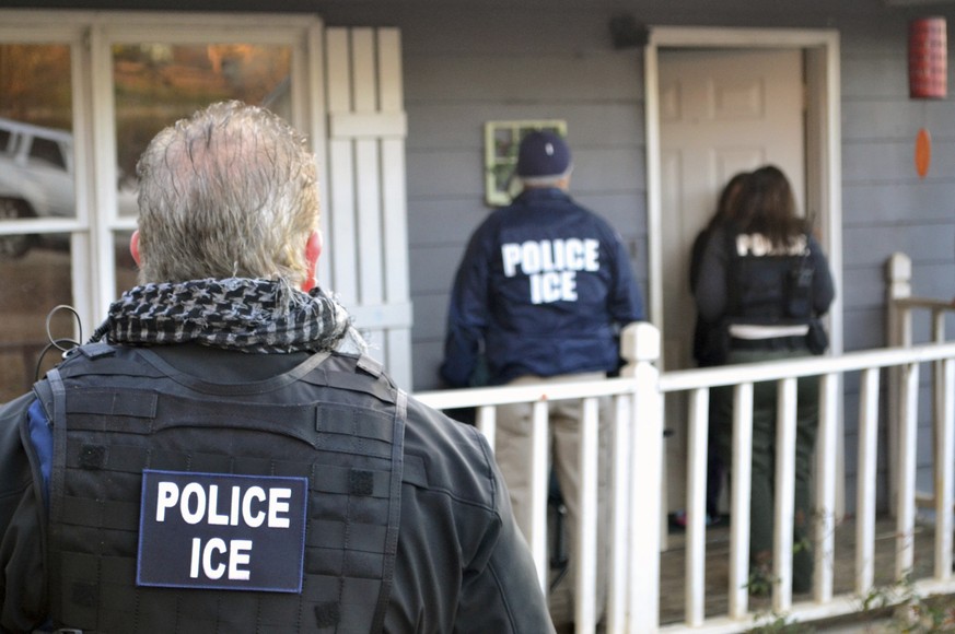 In this Feb. 9, 2017, photo provided U.S. Immigration and Customs Enforcement, ICE agents at a home in Atlanta, during a targeted enforcement operation aimed at immigration fugitives, re-entrants and  ...