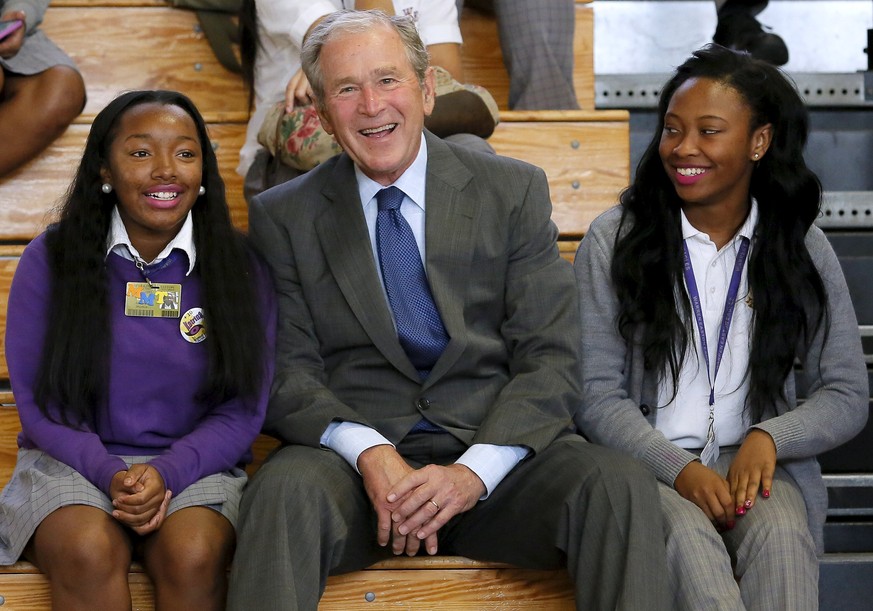 Former U.S. President George W. Bush talks with Ashantae Martin (L), and Ronjae Pleasant at Warren Easton Charter High School one day before the ten year anniversary of Hurricane Katrina in New Orlean ...