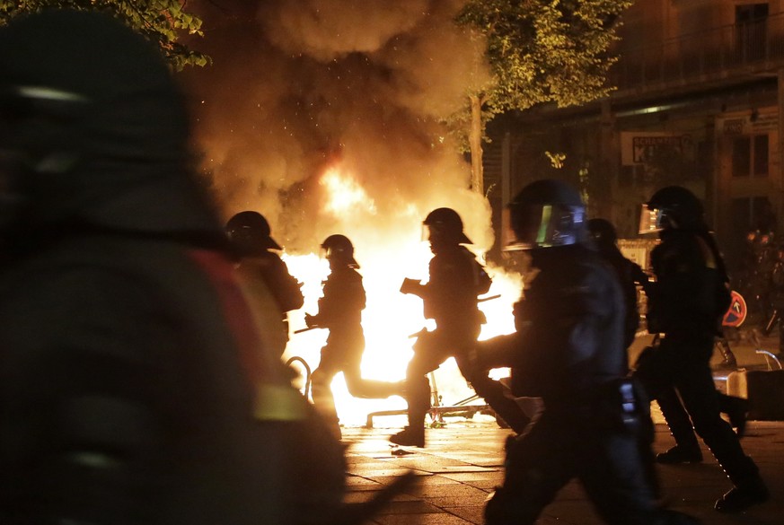 Police officers are silhouetted by fires lit by demonstrators during a protest against the G-20 summit in Hamburg, northern Germany, Thursday, July 6, 2017. The leaders of the group of 20 meet July 7  ...