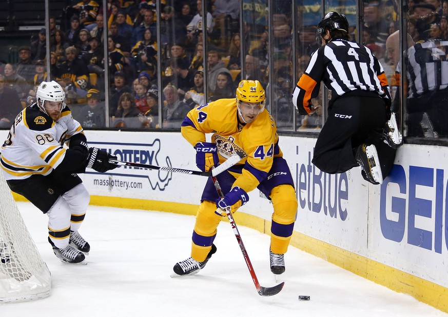 Referee Wes McCauley (4) leaps to avoid Los Angeles Kings center Vincent Lecavalier (44) as Boston Bruins left wing David Pastrnak gives chase during the first period of an NHL hockey game in Boston T ...