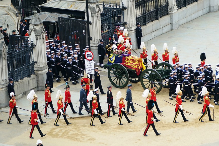 The State Gun Carriage carries the coffin of Queen Elizabeth II, draped in the Royal Standard with the Imperial State Crown as it leaves Westminster Hall for the State Funeral at Westminster Abbey, in ...