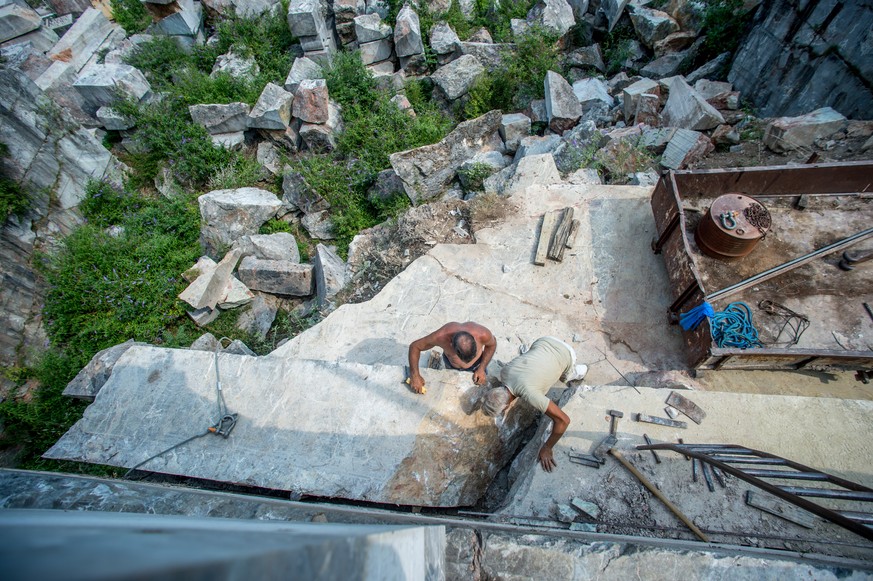 Steinhauer bei der Arbeit mit dem Brekzie-Gestein (Marmor-Granit) im Steinbruch am 19. Juli 2017 in Arzo, Tessin. Der Steinbruch wurde vom Unternehmen Forum Marmo di Arzo (FMA) in Betrieb genommen und ...
