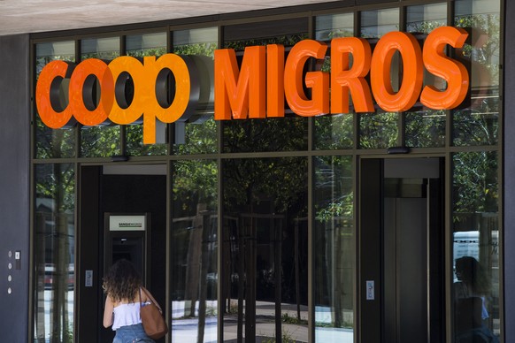 Le logo de la Coop et le logo de la Migros sont photographies cote a cote sur un batiment commercial commun ce mardi 23 aout 2016 sur la place de la Sallaz a Lausanne. (KEYSTONE/Jean-Christophe Bott)