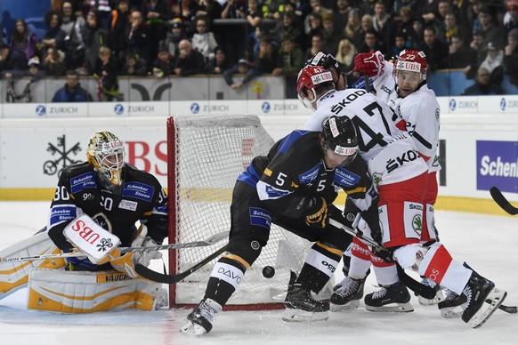 Lugano&#039;s Elvis Merzlikins and Ryan Wilson fight for the puck with Yekaterinburg&#039;s Jan Buchtele and Evgeny Chesalin, from left, during the game between HC Lugano and Avtomobilist Yekaterinbur ...