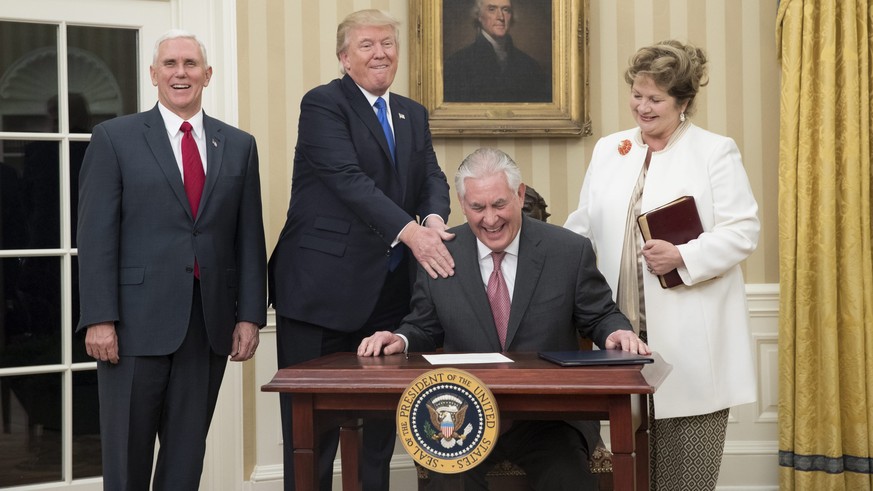 epa05765730 US President Donald J. Trump (2-L) reacts after Rex Tillerson (2-R) signed an appointment affidavit after being sworn-in as US Secretary of State by US Vice President Mike Pence (L), as Ti ...