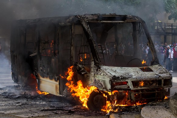 epa05962496 A burning bus during a protest against the Government in Caracas, Venezuela, 13 May 2017. Policemen broke up the protest with tear gas and blocked the different marches in several cities o ...