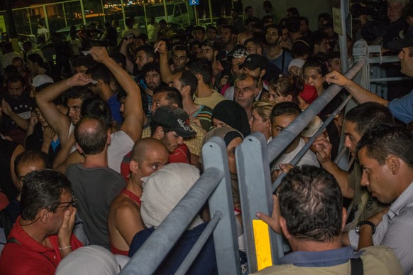 epa04885648 Syrian and other nationalities refugees board a refugee processing ship in the harbour of Kos, on the Greek island Kos, Greece, late 15 August 2015. The Greek island is struggling with a m ...