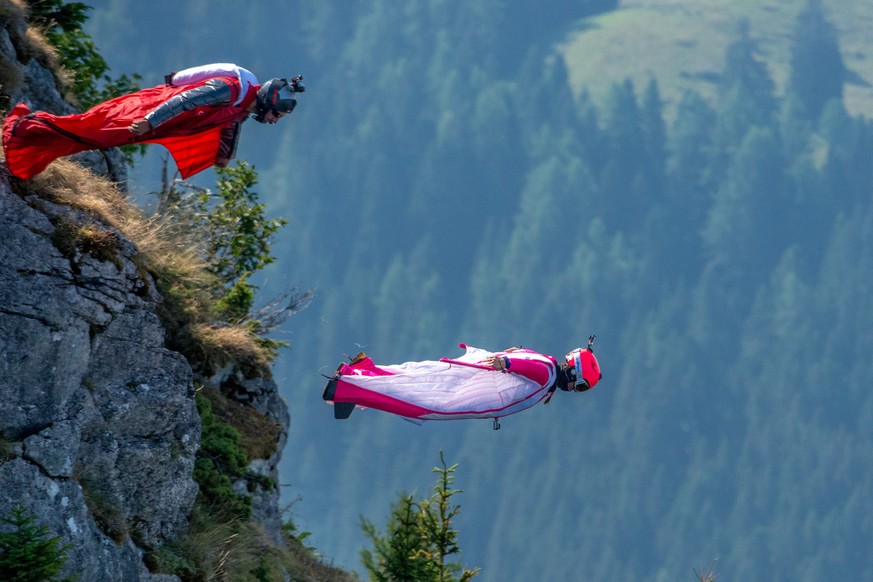 Geraldine Fasnacht, droite, et Rudolph, gauche, s&#039;elancent de la falaise en wingsuit dans le cadre de la conference de presse du Sonchaux Acro Show, ce jeudi 13 aout 2015 a Sonchaux sur les hauts ...