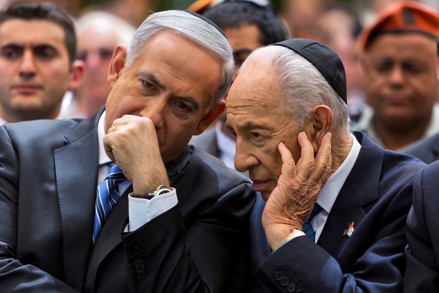 Israeli Prime Minister Benjamin Netanyahu (L) chats with Israeli President Shimon Peres during a ceremony marking Remembrance Day for the fallen soldiers on Mount Herzl Military Cemetery, in Jerusalem ...